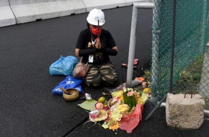 Rara melakukan ritual tradisional agar cuaca cerah saat sesi latihan MotoGP Mandalika 2022 di Sirkuit Internasional Mandalika, Lombok Tengah, Jumat (18/3/2022). [SONNY TUMBELAKA / AFP]