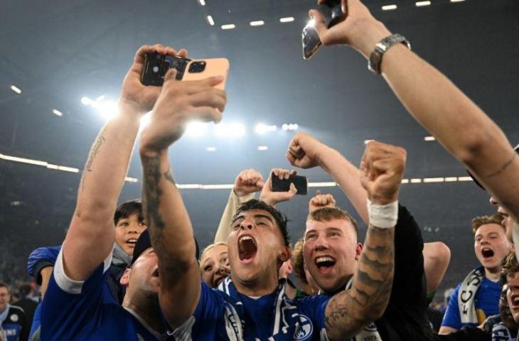 Pemain Schalke Rodrigo Zalazar merayakan keberhasilan timnya kembali ke Bundesliga setelah memenangkan pertandingan divisi kedua Jerman antara FC Schalke 04 dan St. Pauli di Gelsenkirchen, Jerman, 4 Mei 2022. (AFP/INA FASSBENDER)