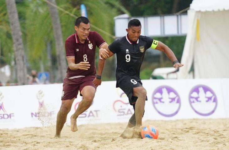 Kapten tim nasional sepak bola pantai Indonesia I Dewa Kadek Dwipayudha (kanan) menggiring bola pada laga Kejuaraan Sepak Bola Pantai AFF 2022 di Pattaya, Thailand, Rabu (28/9/2022). (ANTARA/HO-PSSI)