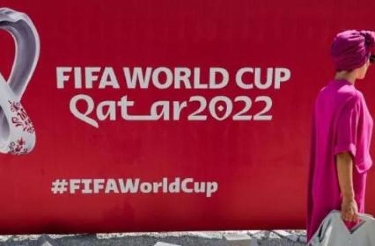 Seorang wanita berjalan di depan baliho besar logo Piala Dunia FIFA 2022 di West Bay Doha, Qatar, pada 13 Oktober 2022. [Dok.Antara]