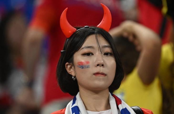 Seorang pendukung Korea Selatan terlihat sedih setelah timnya kalah 1-4 dari Brasil di babak 16 besar Piala Dunia 2022 di Stadion 974 di Doha pada 5 Desember 2022. (AFP/Manan Vatsyayana)