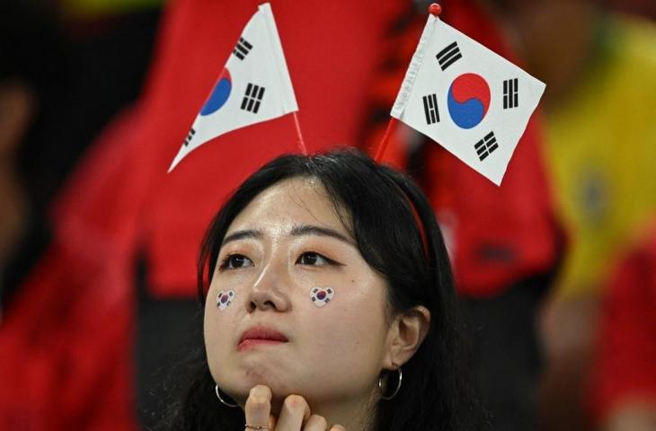 Seorang pendukung Korea Selatan terlihat sedih setelah timnya kalah 1-4 dari Brasil di babak 16 besar Piala Dunia 2022 di Stadion 974 di Doha pada 5 Desember 2022. (AFP/Manan Vatsyayana)