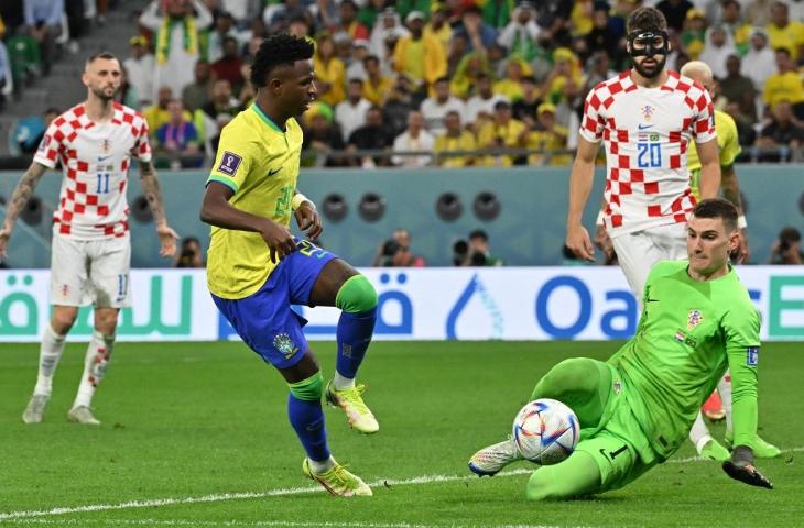 Kiper Kroasia, Dominik Livakovic menghalau tendangan dari penyerang Brasil, Vinicius Jr pada perempat final Piala Dunia di Stadion Education City, Qatar, Jumat (9/12/2022). (Twitter/@CBSSportszo)