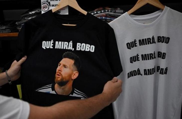 Seorang warga memegang kaus bergambarkan striker Argentina Lionel Messi dan frase yang berarti 