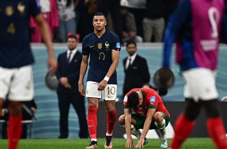 Penyerang Prancis, Kylian Mbappe, berjalan menuju bek Maroko, Achraf Hakimi, pada akhir pertandingan sepak bola semifinal Piala Dunia Qatar 2022 di Stadion Al-Bayt di Al Khor, utara Doha pada 14 Desember 2022 .Prancis menang 2-0. (AFP/Gabriel Bouys)