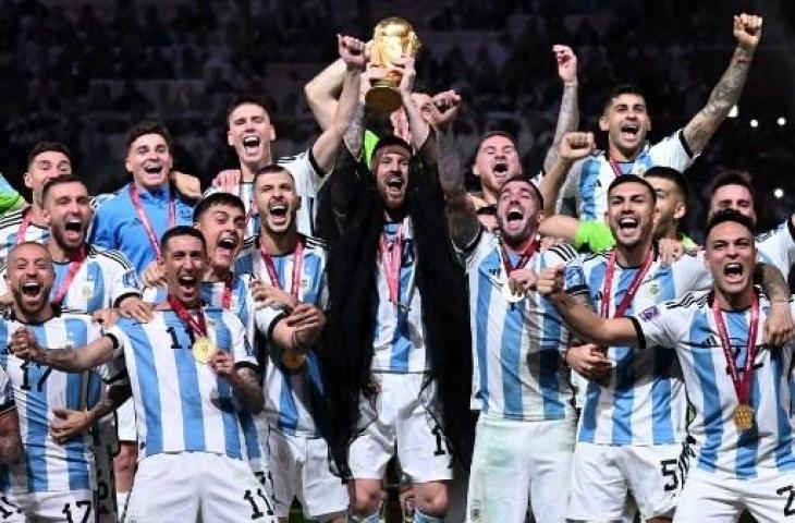 Penyerang Argentina, Lionel Messi, mengangkat Trofi Piala Dunia 2022 bersama pendukung usai mengalahkan Prancis di Stadion Lusail di Lusail, utara Doha pada 18 Desember 2022. (AFP)