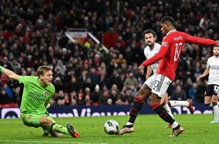 Penyerang Manchester United, Marcus Rashford mencetak gol kedua timnya dengan menaklukan kiper Charlton Athletic, Ashley Maynard-Brewer (kiri) pada laga perempat final Piala Liga Inggris. (Oli SCARFF/AFP)