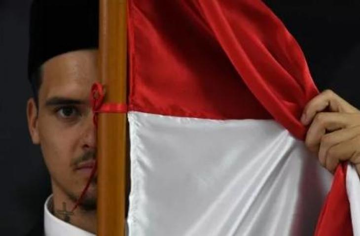 Pesepak bola Shayne Pattynama berpose dengan bendera Merah Putih usai pembacaan sumpah menjadi Warga Negara Indonesia (WNI) di Jakarta, Selasa (24/1/2023). ANTARA FOTO/Aditya Pradana Putra/aww.