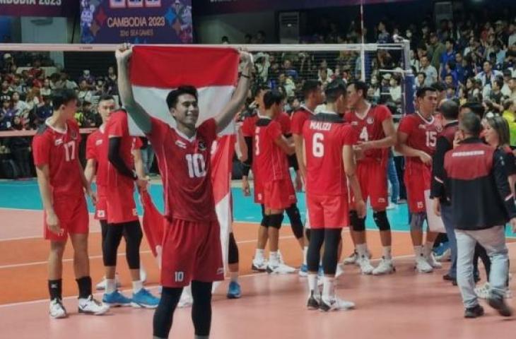 Pemain Timnas bola voli putra Indonesia Fahry Septian mengibarkan bendera Merah Putih usai membantu tim meraih emas SEA Games 2023 Kamboja di Olympic Indoor Stadium, Phnom Penh, Senin (9/5/2023). ANTARA/HO-PBVSI