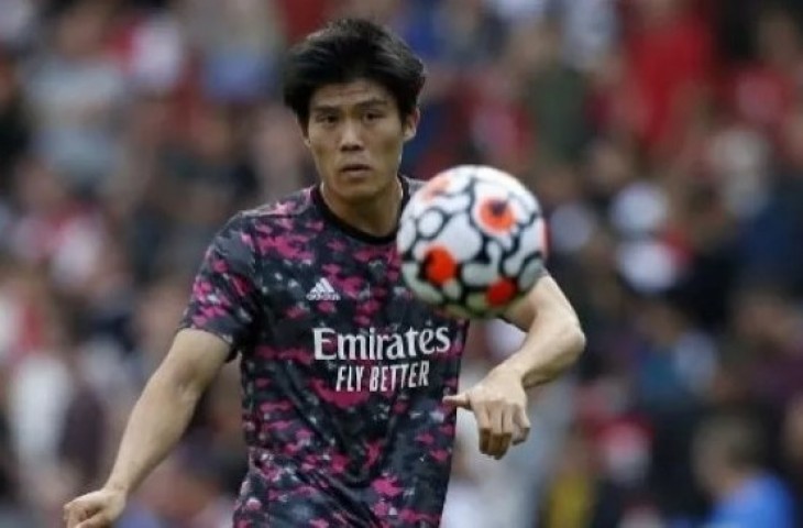 Pemain Arsenal Takehiro Tomiyasu melakukan pemanasan jelang pertandingan Liga Premier Inggris di Emirates Stadium. [suara.com/AFP]