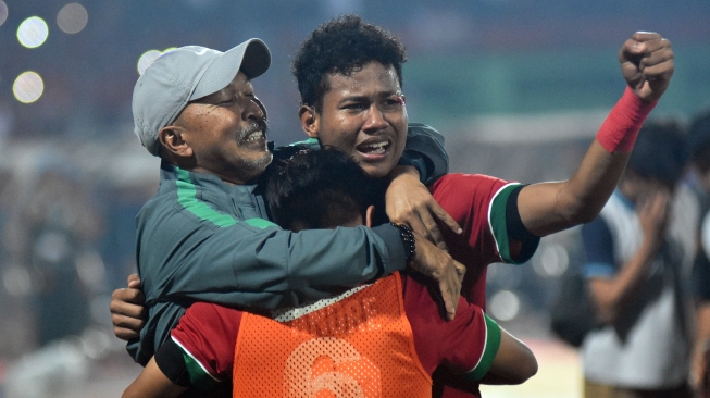 Pelatih Timnas Indonesia U-16 Fakhri Husaini (kiri) memeluk pesepak bola Indonesia Amiruddin Bagas Kaffa Arrizqi (kanan) dan David Maulana (tengah) usai pertandingan Final Piala AFF U-16 melawan Thailand di Stadion Gelora Delta Sidoarjo, Jawa Timur, Sabtu (11/8). Indonesia menjadi juara Piala AFF U-16 usai menang atas Thailand melalui adu pinalti dengan skor 5-4 (1-1). ANTARA FOTO/M Risyal Hidayat