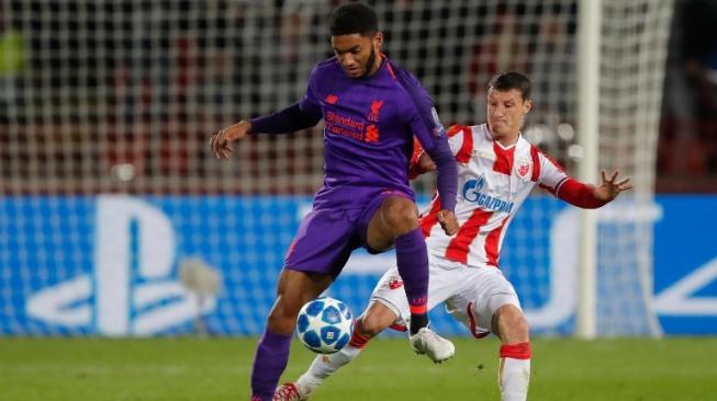 Pemain Liverpool Joe Gomez berebut bola denga pemain Red Star Belgrade,  Slavoljub Srnic, dalam lanjutan pertandingan grup C Liga Champion, Rabu (7/11/2018). (Pedja Milosavljevic / AFP )