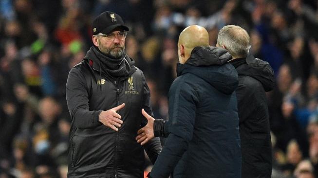  Manajer Liverpool Jurgen Klopp (kiri) bersalaman dengan manajer Manchester City Pep Guardiola usai laga di Etihad Stadium. Oli SCARFF / AFP