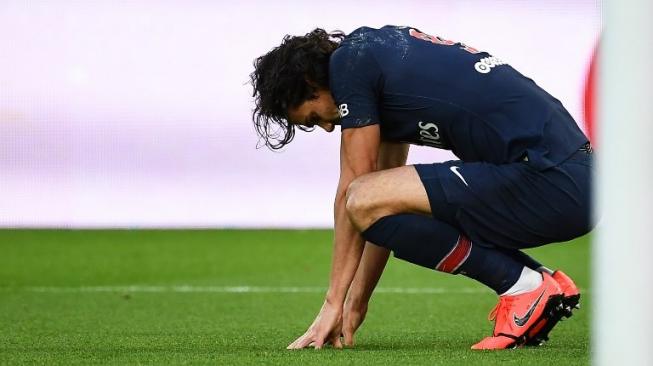 Penyerang andalan Paris Saint-Germain, Edinson Cavani tampak kesakitan pada laga lanjutan Liga Prancis 2018/2019 kontra Girondins Bordeaux di Parc des Princes, Minggu (10/2/2019) dini hari WIB. [Anne-Christine POUJOULAT / AFP]