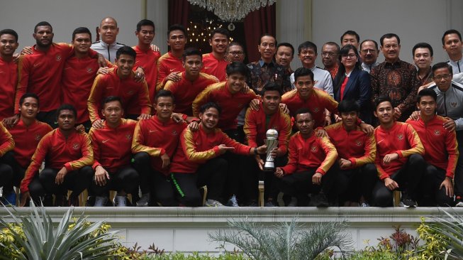 Presiden Joko Widodo (tengah) berfoto dengan pemain Timnas U-22 Indonesia serta ofisial di beranda Istana Merdeka, Jakarta, Kamis (28/2/2019). Presiden memberikan bonus kepada pemain timnas U-22 yang menjadi juara pada kejuaraan AFF U-22 setelah mengalahkan Thailand dengan skor 2-1. Presiden berharap timnas U-22 untuk meningkatkan prestasi selanjutnya dengan menjuarai AFC dan Sea Games. ANTARA FOTO/Wahyu Putro A