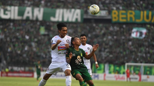 Pesepak bola Persebaya Surabaya Irfan Jaya (kanan) berebut bola di udara dengan pesepak bola Arema FC Jayus Hariono pada laga final leg 1 Piala Presiden 2019 di Gelora Bung Tomo, Surabaya, Jawa Timur, Selasa (9/4/2019). Pertandingan tersebut berakhir imbang dengan skor 2-2. ANTARA FOTO/Zabur Karuru