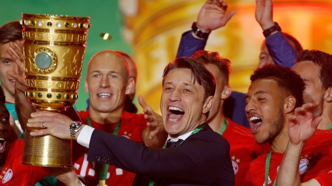 Pelatih Bayern Munich, Niko Kovac (tengah) mengangkat trofi DFB Pokal usai timnya mengalahkan RB Leipzig pada laga final di Stadion Olimpiade Berlin, Minggu (26/5/2019) dini hari WIB. [Odd ANDERSEN / AFP]