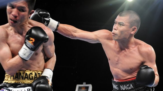 Petinju Indonesia, Chris John (kanan), menghempaskan pukulan ke arah kepala penantangnya, Shoji Kimura (Jepang), dalam pertarungan tinju dunia kelas bulu WBA (Super) di Marina Bay Sands, Singapura, 5 Mei 2012. [AFP/Simin Wang]