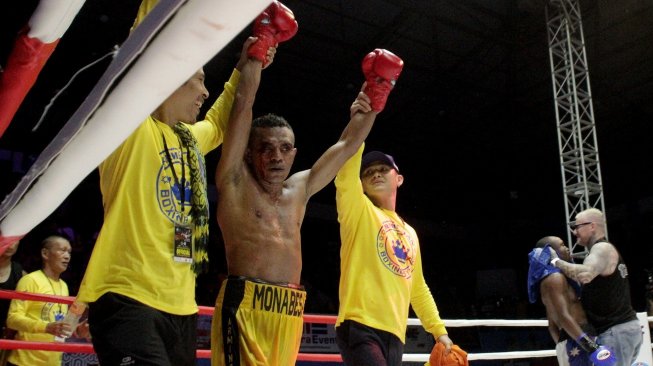 Petinju Indonesia Tibo Monabesa (tengah) diarak keliling ring usai menjuarai perebutan gelar juara dunia kelas terbang ringan IBO melawan petinju Australia Omari Kimweri di GOR Oepoi, Kupang, NTT, Minggu (7/7/2019). [Antara/Kornelis Kaha]