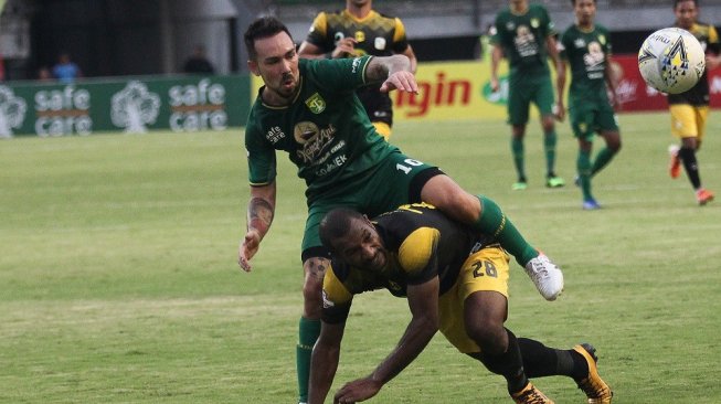 Pesepak bola Persebaya Damian Emanuel Lizio (kiri) mencoba melewati hadangan pesepak bola PS Barito Putera Andri Ibo (kanan) saat pertandingan Liga 1 2019 di Stadion Gelora Bung Tomo, Surabaya, Jawa Timur, Selasa (9/7/2019). Persebaya ditahan imbang PS Barito Putera dengan skor akhir 2-2. ANTARA FOTO/Moch Asim