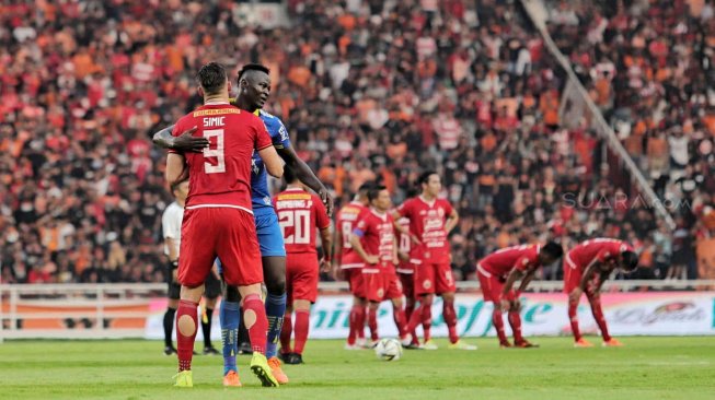 Striker Persija Jakarta Marko Simic berpelukan dengan pemain pesepakbola Persib Bandung Ezechiel Ndouasel usai pertandingan di Stadion Utama Gelora Bung Karno (SUGBK), Senayan, Jakarta, Rabu (10/7). (Suara.com/Muhaimin A Untung)