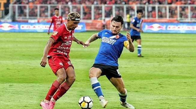 Pesepak bola Persija Jakarta Bruno Matos dihalau dari dengan pesepak bola PSM Makassar Marc Klok dalam pertandingan Final Piala Indonesia 2018-2019 leg pertama di Stadion Utama Gelora Bung Karno (GBK), Senayan, Jakarta, Minggu (21/7). [Suara.com/Muhaimin A Untung]