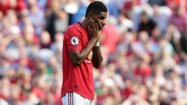 Ekspresi penyerang Manchester United, Marcus Rashford saat gagal mengeksekusi tendangan penalti kala menjamu Crystal Palace di Stadion Old Trafford, Sabtu (24/8/2019). (LINDSEY PARNABY / AFP)