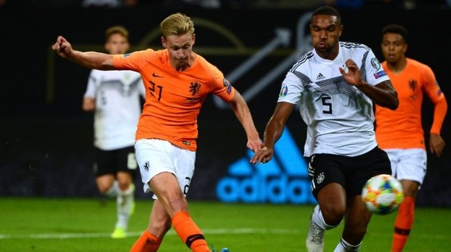 Bek Timnas Belanda, Frenkie de Jong (kiri) melepas tendangan ke gawang Jerman pada lanjutan kualifikasi Piala Eropa 2020 antara Jerman vs Belanda di Stadion Volkspark, Hamburg, Sabtu (7/9/2019). (PATRIK STOLLARZ / AFP)