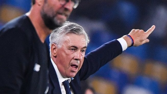 Pelatih Napoli, Carlo Ancelotti memberi arahan kepada anak asuhnya saat menghadapi Liverpool padababak penyisihan Grup E Liga Champions 2019/20 di Stadion San Paolo, Italia, Rabu (18/9/2019). (Alberto PIZZOLI / AFP)