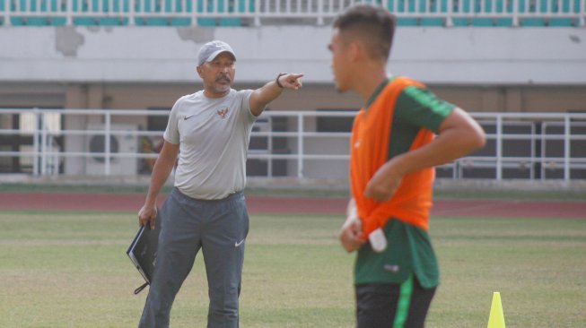 Pelatih timnas Indonesia U-19 Indonesia Fakhri Husaini (kiri) memberikan instruksi kepada para pemainnya saat latihan di Stadion Pakansari, Cibinong, Bogor, Jawa Barat, Senin (30/9/2019). ANTARA FOTO/Yulius Satria Wijaya