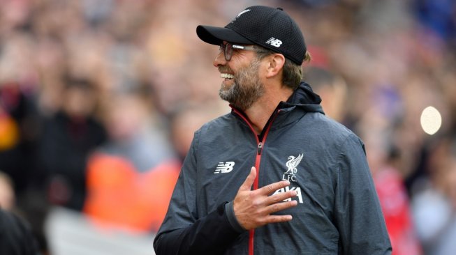 Manajer Liverpool, Jurgen Klopp tersenyum saat timnya menjamu Leicester City dalam laga lanjutan Liga Inggris 2019/2020 di Anfield, Liverpool, Sabtu (5/10/2019) malam WIB. [Paul ELLIS / AFP]