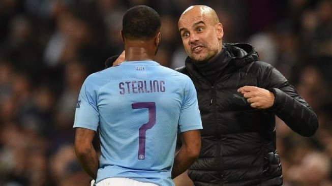 Manajer Manchester City Pep Guardiola (kanan) berbicara dengan Raheem Sterling saat menghadapi Atalanta di Etihad Stadium dalam laga Liga Champions Grup C. Oli SCARFF / AFP