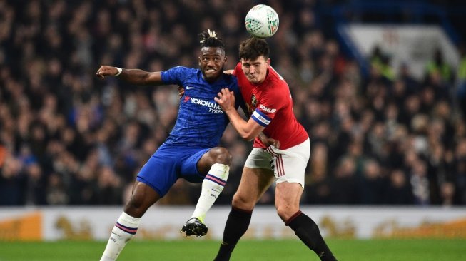 Penyerang Chelsea, Michy Batshuayi berduel dengan kapten Manchester United, Harry Maguire pada lanjutan Piala Liga Inggris 2019/20 di Stadion Stamford Bridge, Kamis (31/10/2019). [Glyn KIRK / AFP]