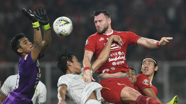 Pesepak bola Persija Jakarta Marko Simic (kedua kanan) berusaha menyundul bola dengan dihadang penjaga gawang Persebaya Surabaya Miswar Saputra (kiri) dalam lanjutan Liga-1 Indonesia di Stadion Utama Gelora Bung Karno (GBK), Jakarta, Selasa (17/12/2019). ANTARA FOTO/M Risyal Hidayat/aww.