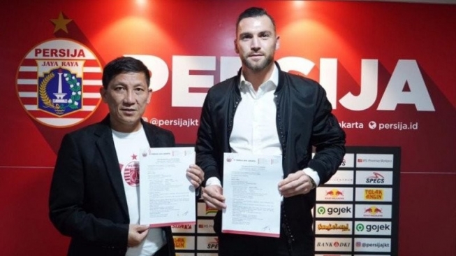 CEO klub Persija Jakarta Ferry Paulus (kiri) dan penyerang Persija Marko Simic berfoto bersama usai penandatanganan kontrak baru Simic di Kantor Persija, Jakarta, Rabu (18/12/2019). (Persija Jakarta)