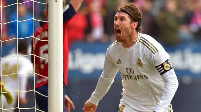 Kapten Real Madrid, Sergio Ramos merayakan golnya ke gawang Osasuna pada laga Liga Spanyol 2019/2020 di Estadio El Sadar, Minggu (9/2/2020) malam WIB. [ANDER GILLENEA / AFP]