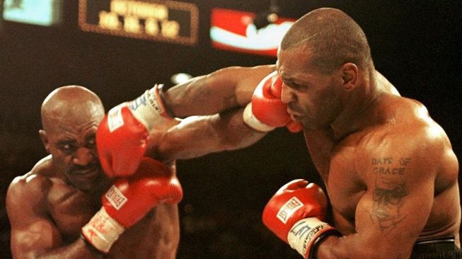 Mike Tyson (kanan) dan Evander Holyfield saling melancarkan pukulan dalam duel tinju dunia di MGM Grand Garden Arena, Las Vegas, Sabtu (28/6/1997). [AFP/Jeff Haynes]