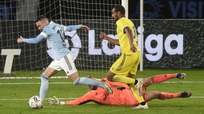 Penyerang Celta Vigo Iago Aspas menggocek kiper Cadiz Jeremias Ledesma dalam pertandingan pekan ke-13 Liga Spanyol di stadion Abanca Balaidos, Selasa (15/12/2020) dini hari WIB. [MIGUEL RIOPA / AFP]