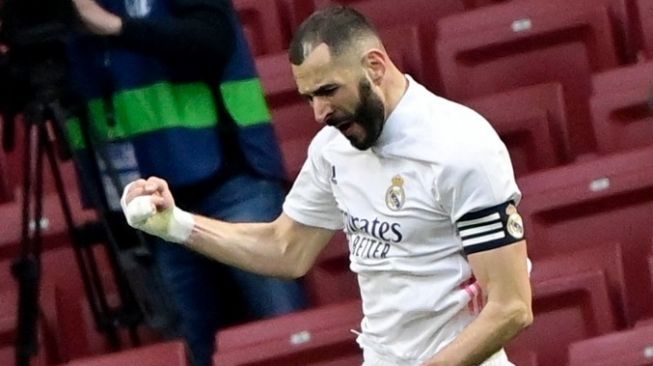 Penyerang Real Madrid, Karim Benzema merayakan golnya ke gawang Atletico Madrid pada laga Liga Spanyol 2020/2021 di Estadio Wanda Metrpolitano, Minggu (7/3/2021) malam WIB. [JAVIER SORIANO / AFP]