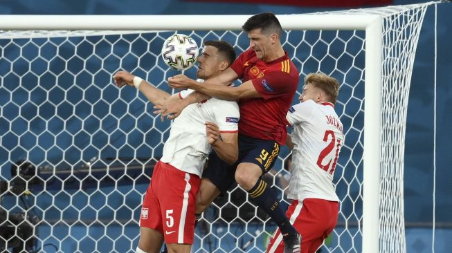 Penyerang Spanyol Gerard Moreno (tengah) menyundul bola dengan bek Polandia Jan Bednarek (kiri) dan gelandang Polandia Kamil Jozwiak selama pertandingan sepak bola Grup E UEFA EURO 2020 antara Spanyol dan Polandia di Stadion La Cartuja, Seville, Spanyol, pada (19/6/2021). [LLUIS GENE / POOL / AFP]