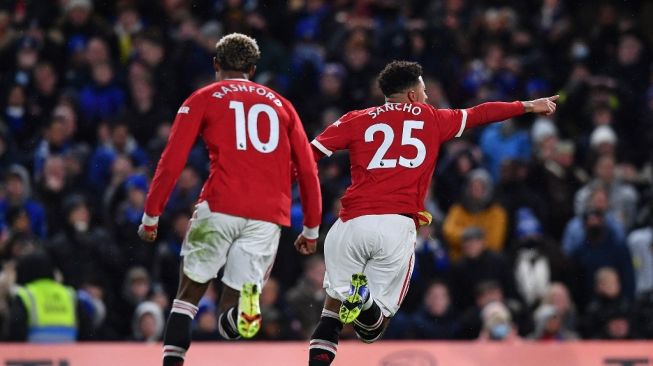 Winger Manchester United asal Inggris, Jadon Sancho (kanan) berlari untuk merayakan gol pembuka timnya selama pertandingan pekan ke-13 Liga Inggris antara Chelsea vs Manchester United di Stamford Bridge, London pada 29 November 2021.Ben STANSALL / AFP.