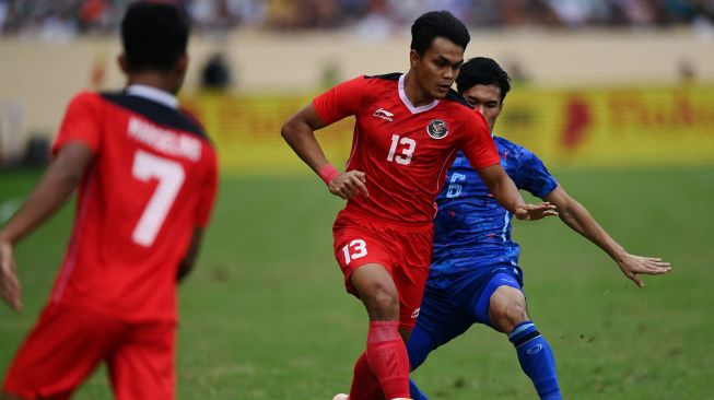 Pesepak bola Timnas Indonesia Rachmat Irianto (tengah) berebut bola dengan pesepak bola Timnas Thailand Airfan Doloh (kanan) dalam pertandingan semifinal sepak bola SEA Games 2021 Vietnam di Stadion Thien Truong, Nam Dinh, Vietnam, Kamis (19/5/2022). ANTARA FOTO/Aditya Pradana Putra