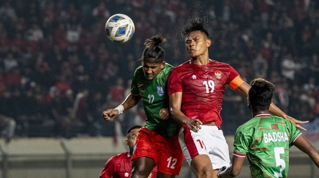 Pesepak bola Timnas Indonesia Fachrudin Aryanto (tengah) dan pesepak bola Bangladesh Bishwanath Ghosh (kiri) berebut bola di udara saat laga persahabatan FIFA di Stadion Si Jalak Harupat, Kabupaten Bandung, Jawa Barat, Rabu (1/6/2022). ANTARA FOTO/M Agung Rajasa/nz