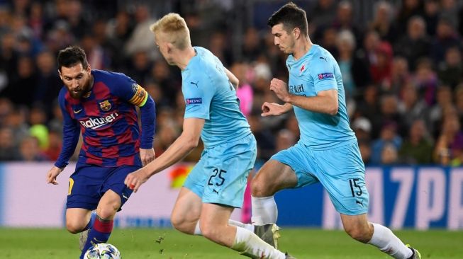 Bek Slavia Praha, Ondrej Kudela (kanan) dan Michal Frydrych coba merebut bola dari pemain Barcelona Lionel Messi (kiri) dalam pertandingan Grup F Liga Champions antara Barcelona vs Slavia Praha di stadion Camp Nou di Barcelona pada 5 November 2019.Josep LAGO / AFP.