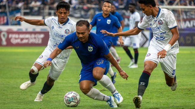 SPesepak bola PSIS Semarang Wawan Febrianto (tengah) berupaya melewati hadangan pesepak bola Arema FC Irsyad Maulana (kiri) dan Achmad Figo (kanan) saat pertandingan semifinal leg 1 Piala Presiden 2022 di Stadion Jatidiri Semarang, Jawa Tengah, Kamis (7/7/2022). [ANTARA FOTO/Aji Styawan/hp]