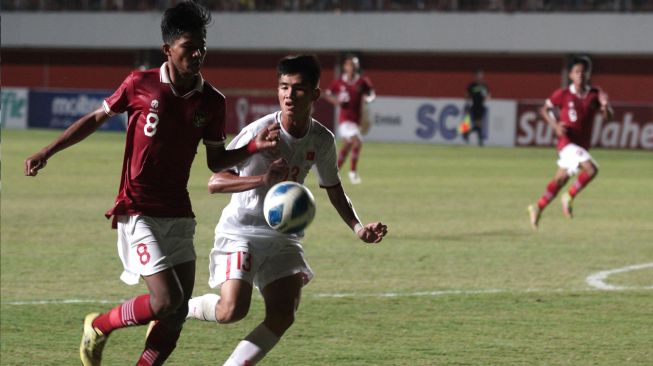 Pemain Timnas Indonesia U-16 Arkhan Kaka Putra Purwanto (kiri) berebut bola dengan pemain Timnas Vietnam U-16 Nguyen Huu Troong (kedua kiri) pada laga AFF U-16 2022 di Stadion Maguwoharjo, Depok, Sleman, D.I Yogyakarta, Sabtu (6/7/2022). [ANTARA FOTO/Andreas Fitri Atmoko/rwa]