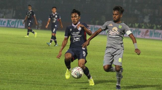 Pesepak bola Arema FC Arkhan Fikri (kiri) berebut bola dengan pesepak bola Persebaya Surabaya Muhammad Alwi Slamat (kanan) dalam pertandingan lanjutan BRI Liga 1 di Stadion Kanjuruhan, Malang, Jawa Timur, Sabtu (1/10/2022). ANTARA FOTO/Ari Bowo Sucipto/tom. 