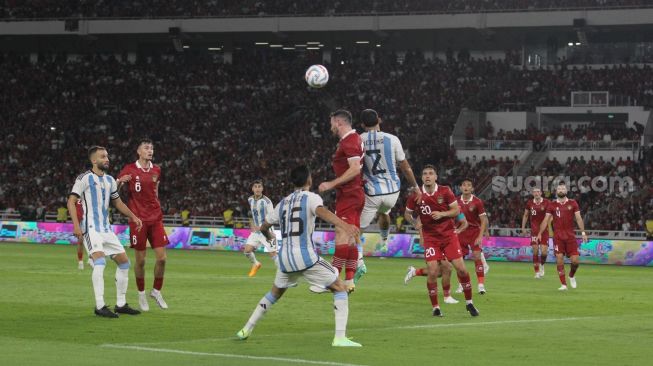 Pemain Timnas Indonesia Jordi Amat bertarung memperebutkan bola di udara dengan pemain Argentina dalam pertandingan FIFA Matchday di Stadion Utama Gelora Bung Karno, Senin (19/6/2023). [Suara.com/Dwi Bowo Raharjo]