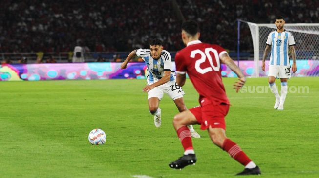 Pemain Timnas Argentina Nahuel Molina mencoba melewati pemain Timnas Indonesia Shayne Pattynama pada laga FIFA Matchday di Stadion Utama Gelora Bung Karno, Senayan, Jakarta, Senin (19/6/2023) malam. [Suara.com/Dwi Bowo Raharjo]