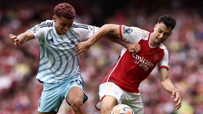 Striker Nottingham Forest, Brennan Johnson (kiri) bersaing dengan gelandang Arsenal Gabriel Martinelli selama pertandingan sepak bola Liga Inggris antara Arsenal vs Nottingham Forest di Stadion Emirates di London pada 12 Agustus 2023.HENRY NICHOLLS / AFP.